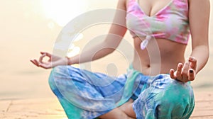 Yoga on the beach. Happy asian woman wearing Tie Dye bikini practicing yoga. Young healthy womanÂ on Summer yogaÂ at sunset